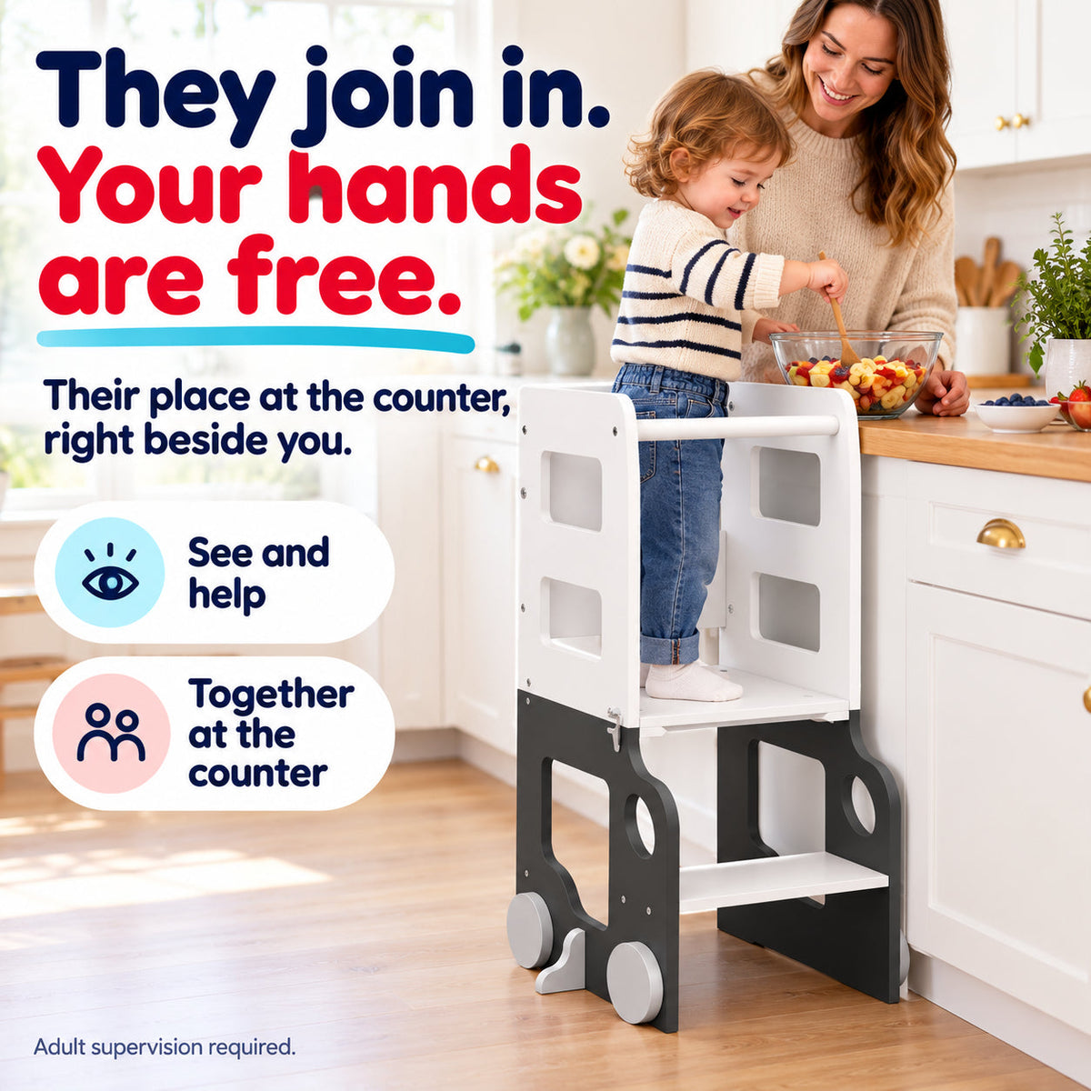 Child joins parent at kitchen counter using the white and dark grey foldable learning tower