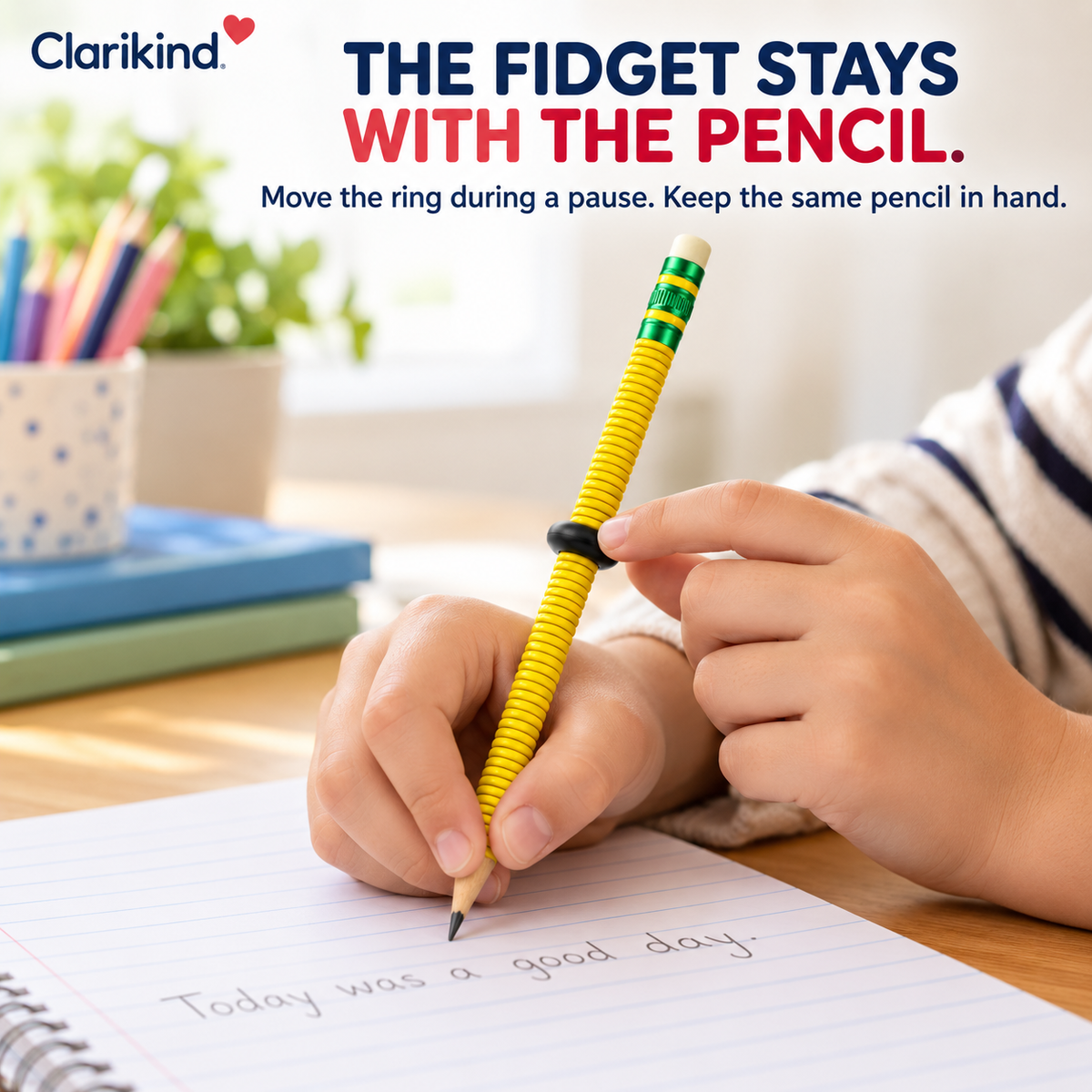 Child writing with the Clarikind yellow fidget pencil and moving its black ring during a short pause.