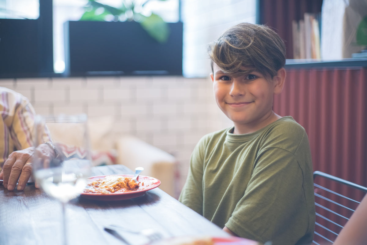 Child sitting at a family dinner table