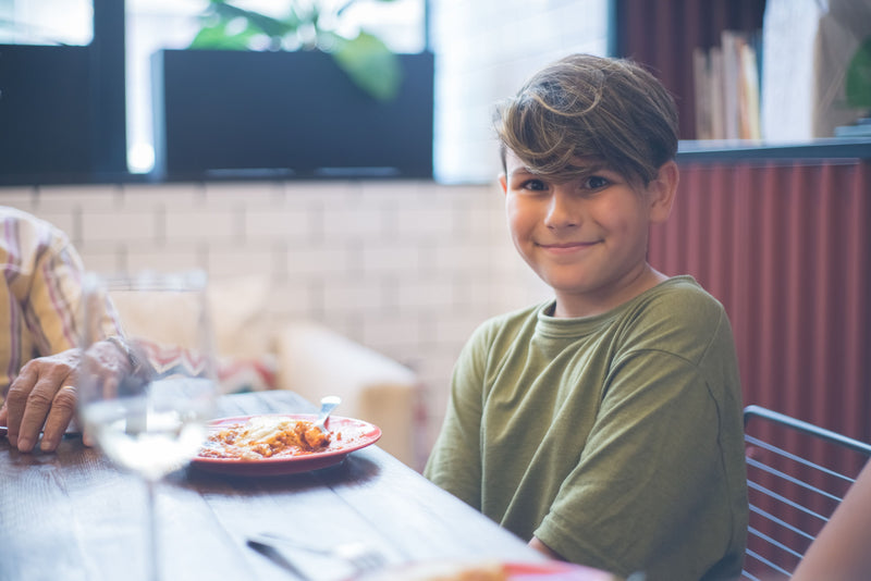 Child sitting at a family dinner table