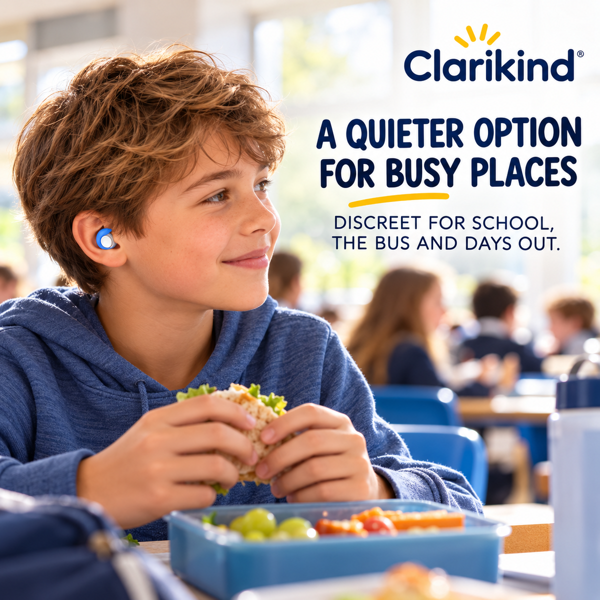 Child wearing a discreet noise-reducing earplug in a busy school canteen