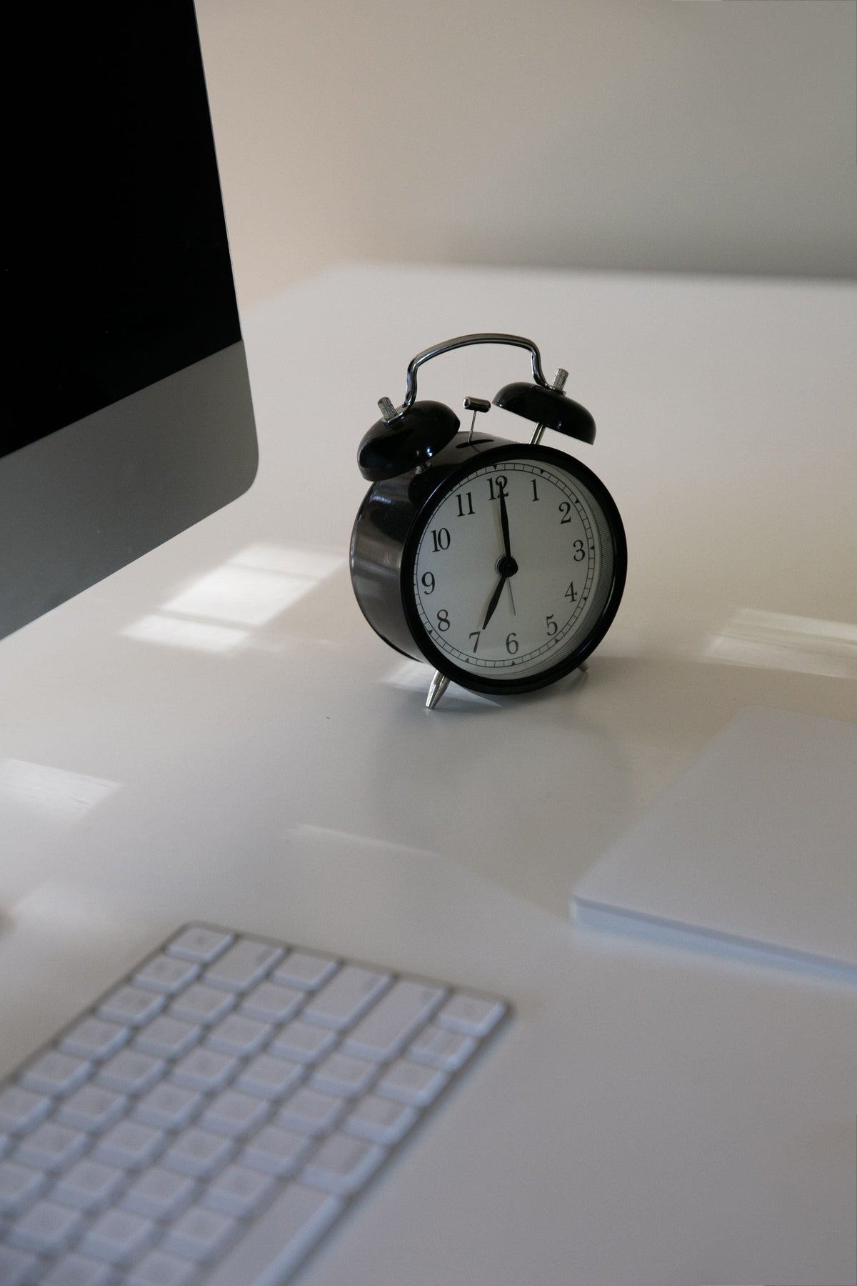 Clock beside a computer screen representing a clear screen-time ending