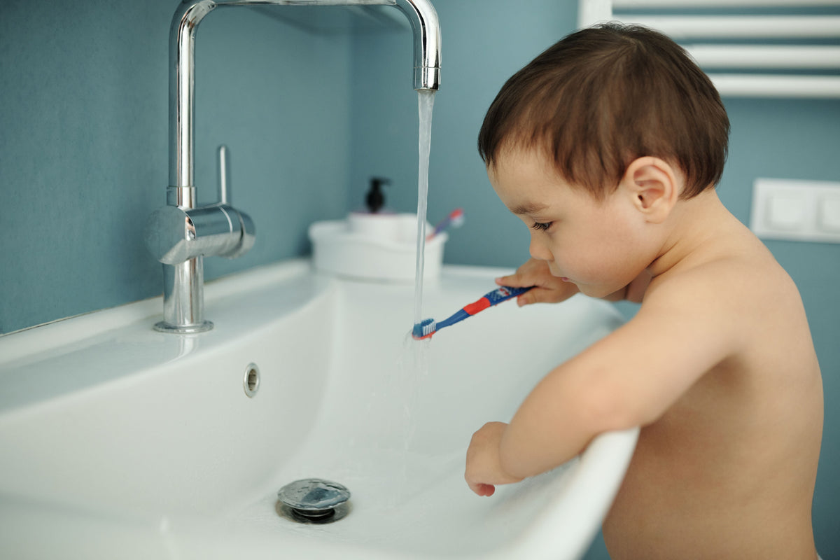 Child at a bathroom sink during a personal-care routine