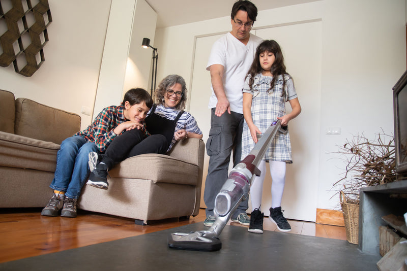 Family using a vacuum cleaner in a living room