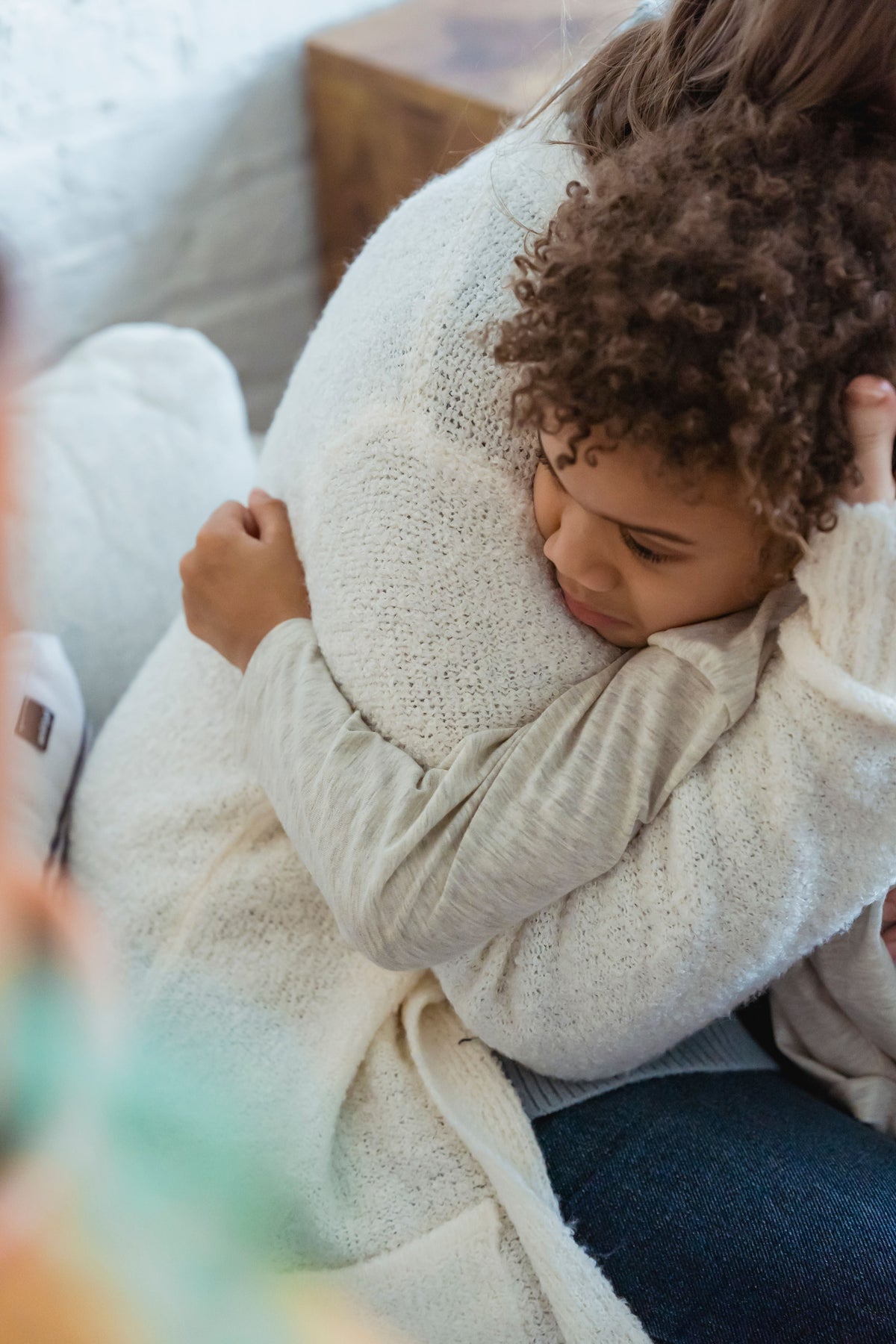 Parent comforting a child during an emotional moment at home