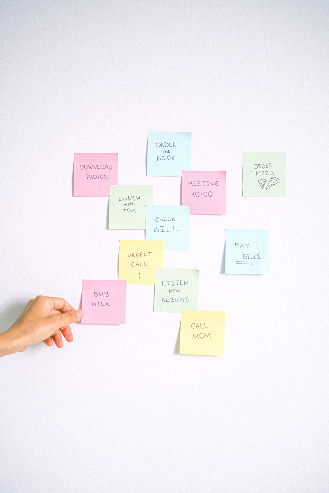 Hand arranging colourful visual reminder notes
