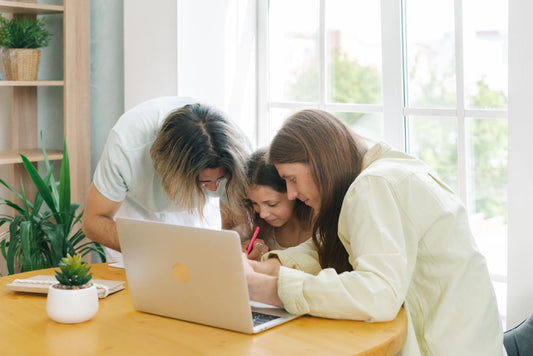 Parents supporting a child with homework at a table